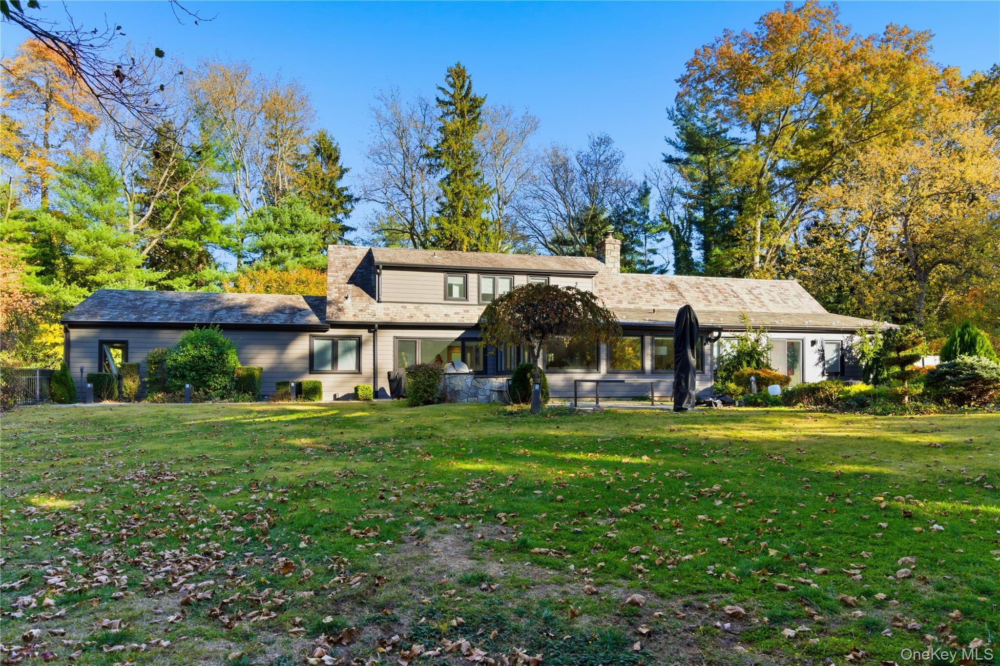 108 Bacon Road Old Westbury, NY 11568 - Photo 29 of 39 a view of a big house with a big yard and large trees