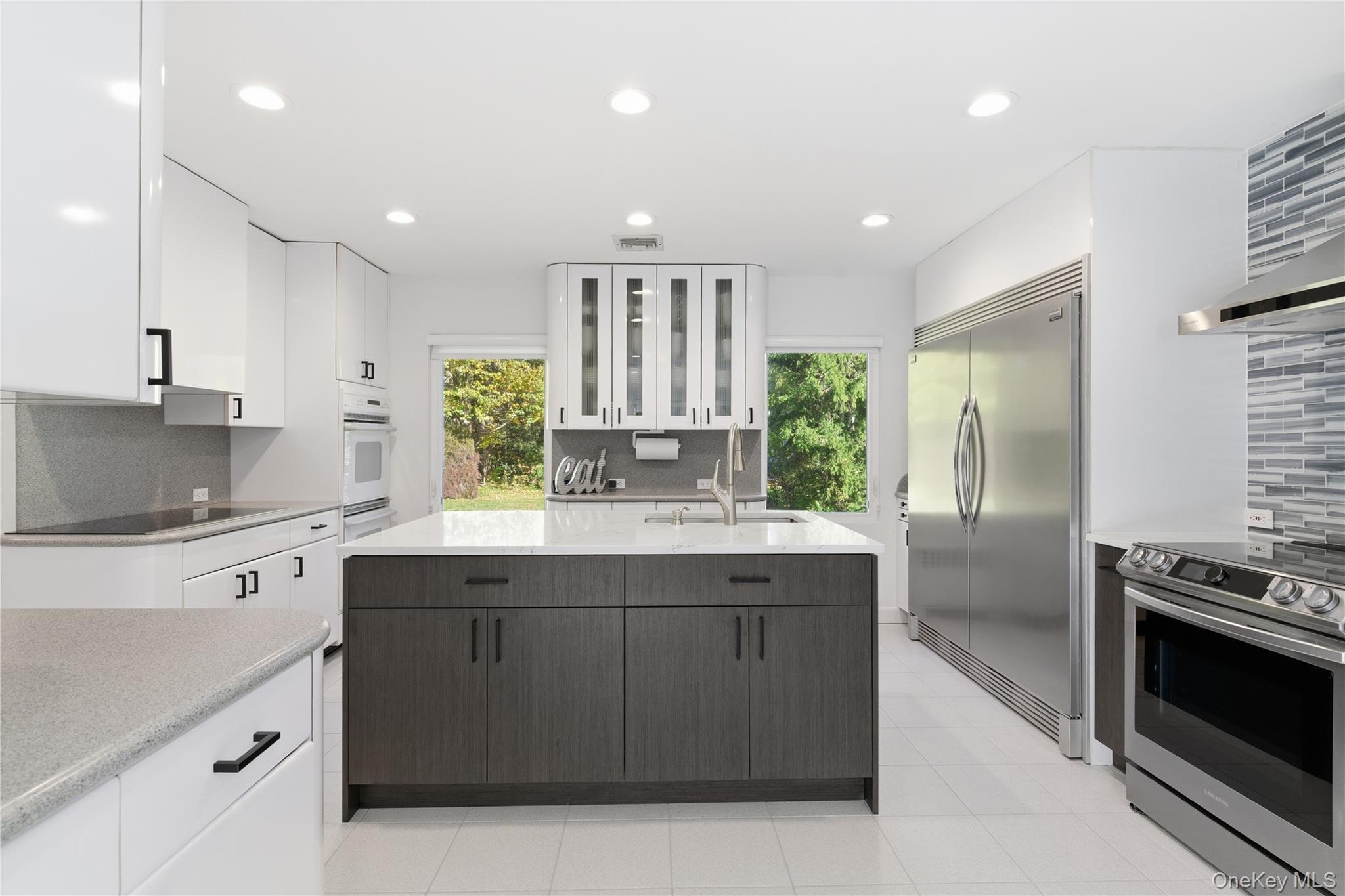 108 Bacon Road Old Westbury, NY 11568 - Photo 6 of 39 a kitchen with stainless steel appliances granite countertop a sink a stove and a refrigerator