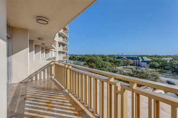 a view of a balcony with wooden floor and fence