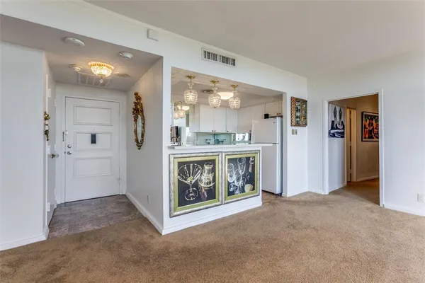 a view of an empty room with furniture and a window