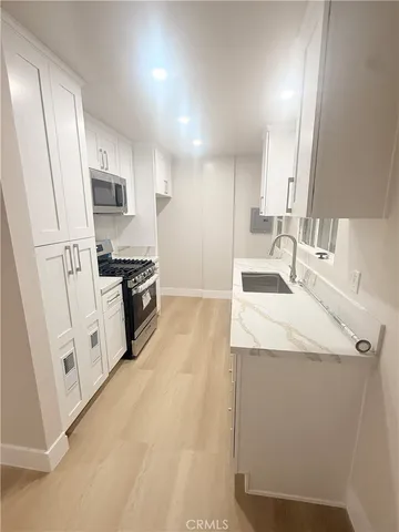 a kitchen with granite countertop a sink stove and refrigerator