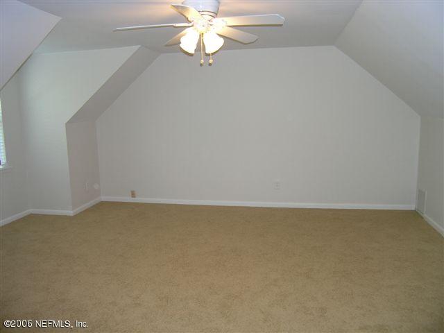 100 Cat Road Ponte Vedra Beach, FL 32082 - Photo 7 of 14 an empty room with a chandelier fan and windows