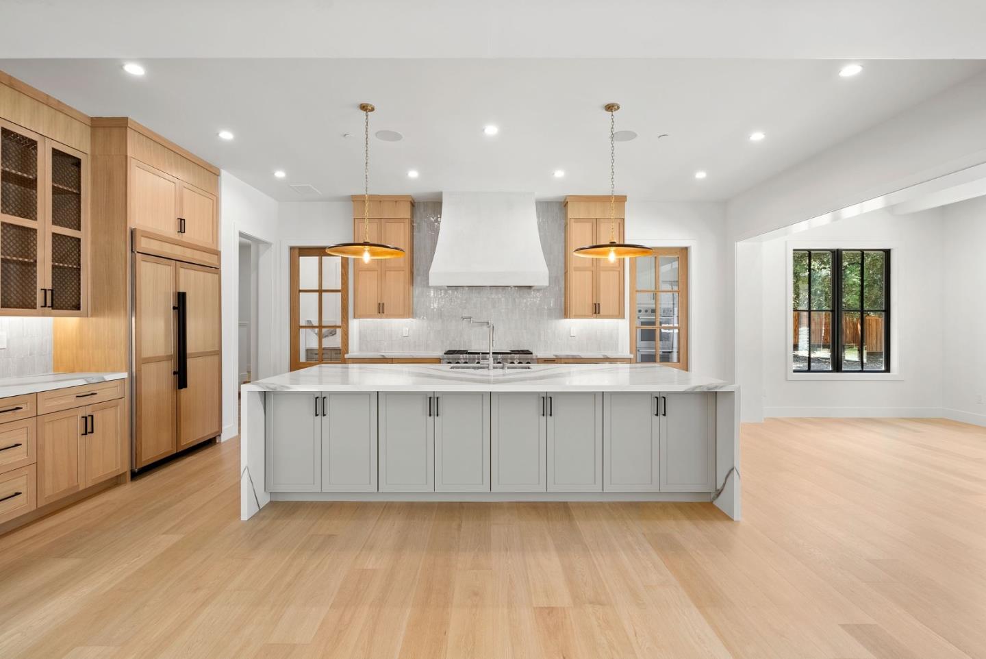 18521 Vessing Road Saratoga, CA 95070 - Photo 6 of 36 a large kitchen with stainless steel appliances kitchen island granite countertop a stove a sink a refrigerator and white cabinets with wooden floor