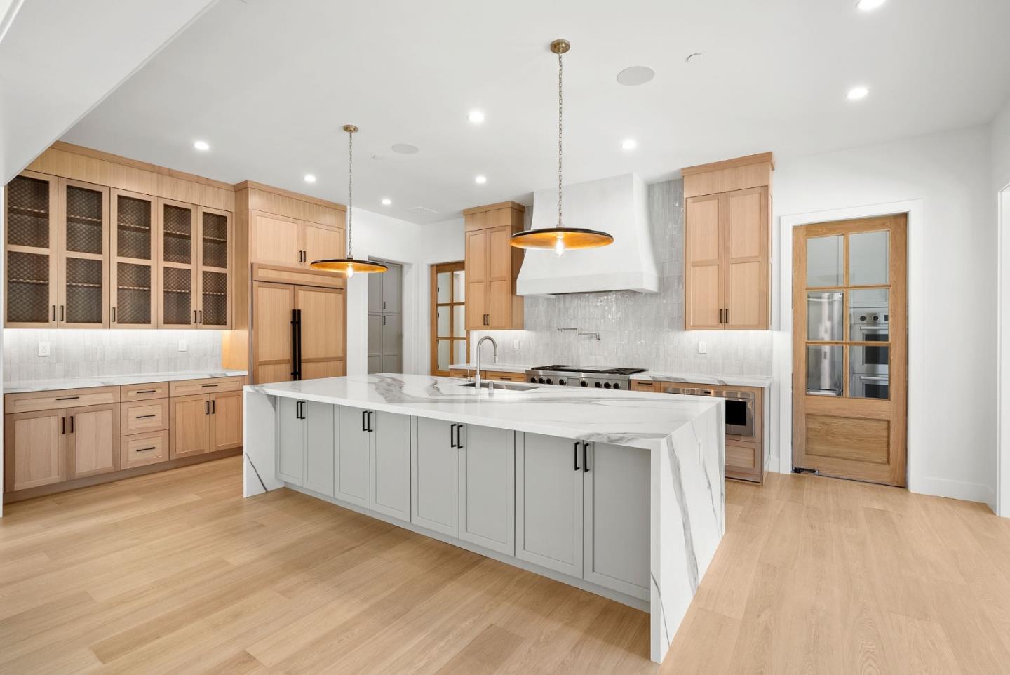 18521 Vessing Road Saratoga, CA 95070 - Photo 7 of 36 a large kitchen with stainless steel appliances kitchen island granite countertop a stove a sink a refrigerator and white cabinets with wooden floor