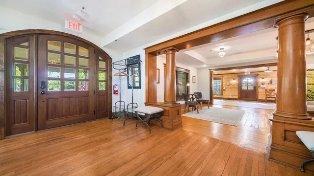 a living room with furniture large window and wooden floor