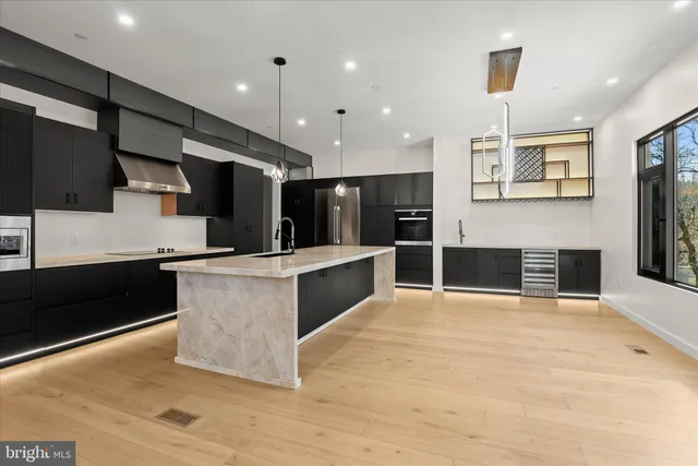 a large kitchen with stainless steel appliances a large counter top