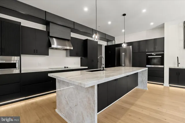 a large kitchen with kitchen island a large island in it