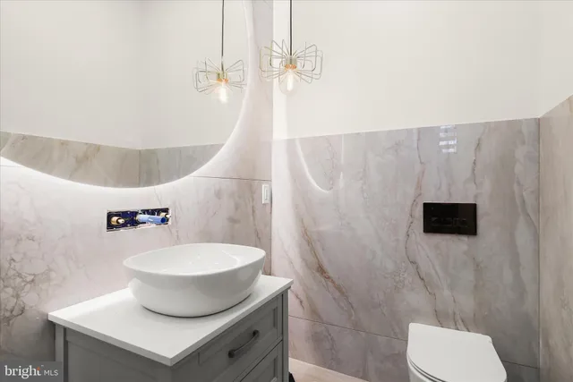 a white toilet sitting next to a bathroom sink