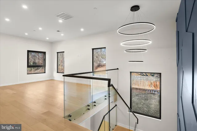a view of an empty room with wooden floor and window