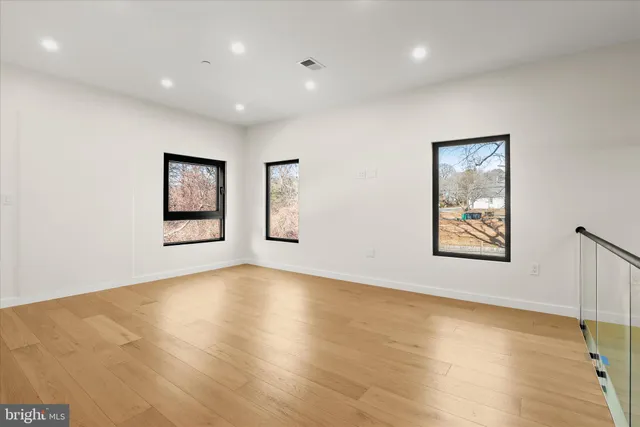 a view of an empty room with a window and a ceiling fan