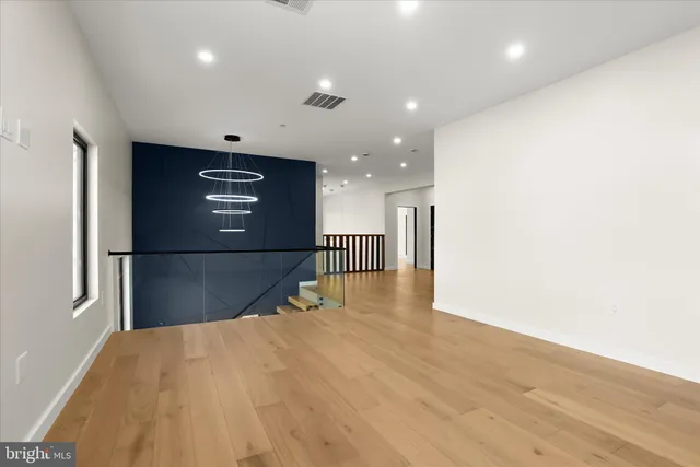 a view of an empty room with a window and a kitchen