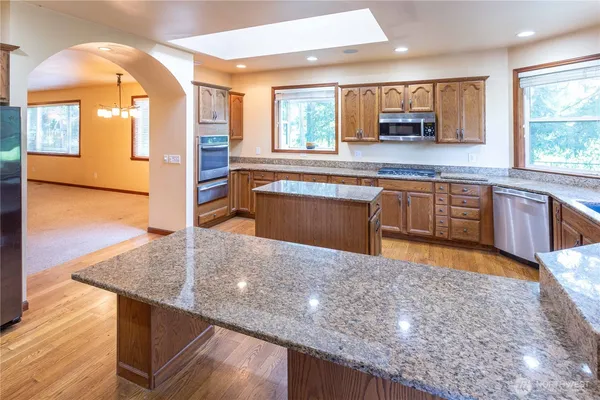 a kitchen with stainless steel appliances granite countertop a sink and a counter space