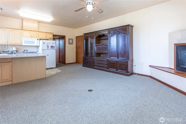 a kitchen with stainless steel appliances granite countertop a refrigerator a sink dishwasher and white cabinets with wooden floor