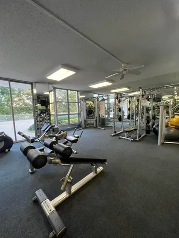 a room with gym equipment and large windows