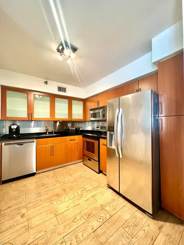a kitchen with stainless steel appliances granite countertop a refrigerator and a sink