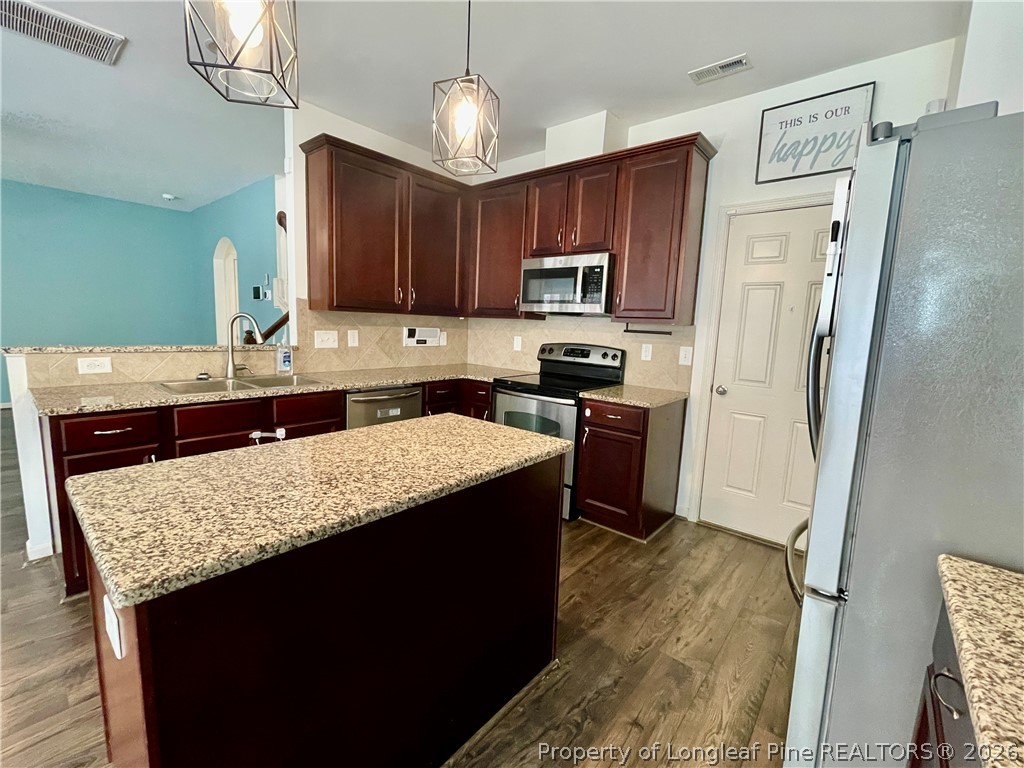 144 Bicentennial Way Cameron, NC 28326 - Photo 8 of 23 a kitchen with stainless steel appliances granite countertop wooden cabinets a refrigerator a stove a sink and dishwasher