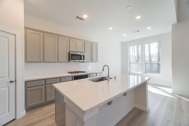 a kitchen with stainless steel appliances a refrigerator sink and stove