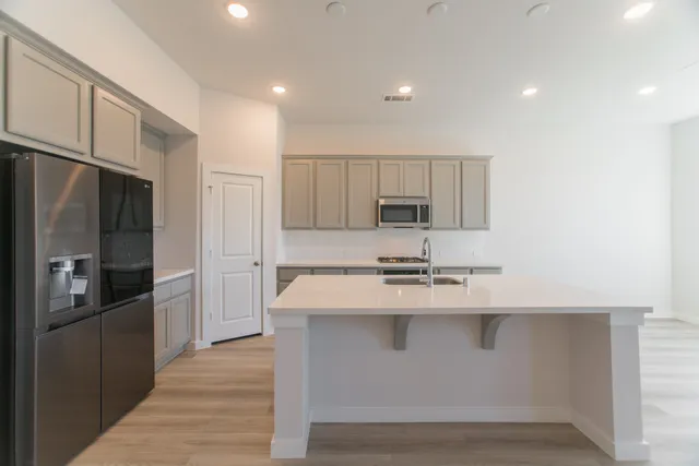 a kitchen with white cabinets and stainless steel appliances