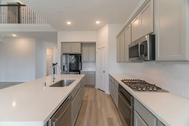 a kitchen with stainless steel appliances granite countertop a sink stove and cabinets