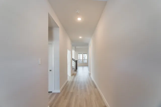 a view of hallway with stairs and wooden floor