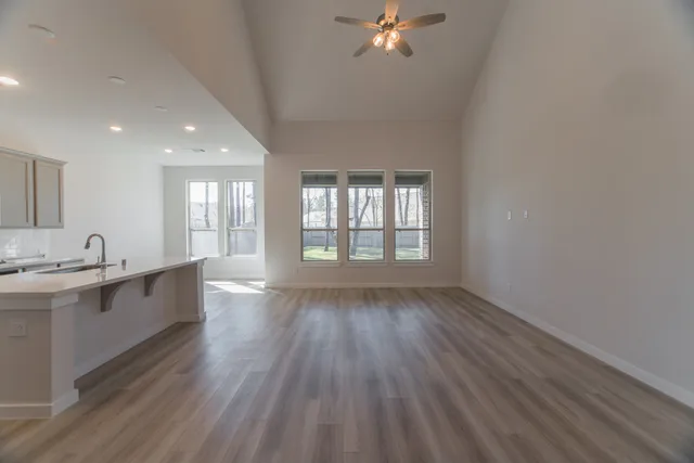 a large white kitchen with kitchen island a sink stainless steel appliances and cabinets