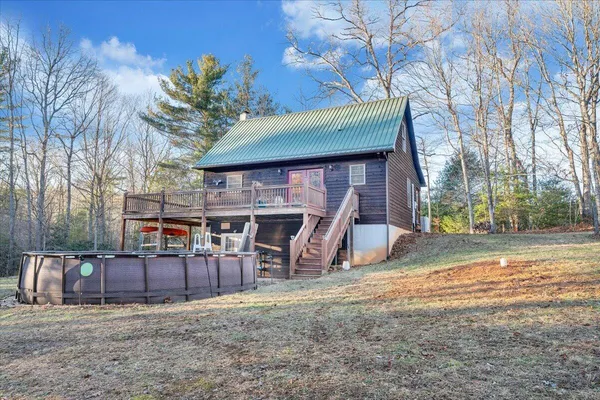 a backyard of a house with table and chairs under an umbrella