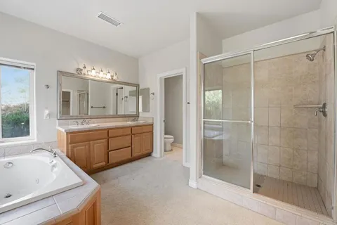 a bathroom with a granite countertop sink a toilet and mirror