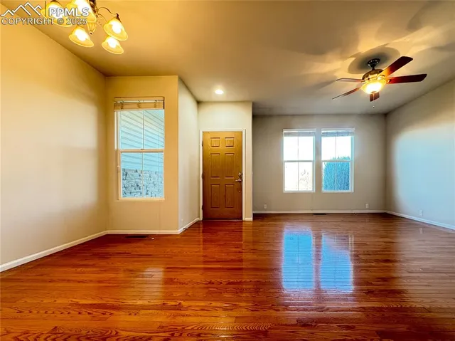 a view of empty room with wooden floor