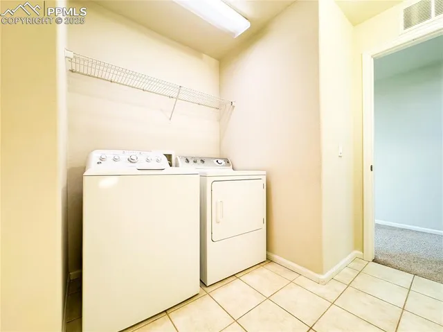 an empty room with a chandelier fan and windows