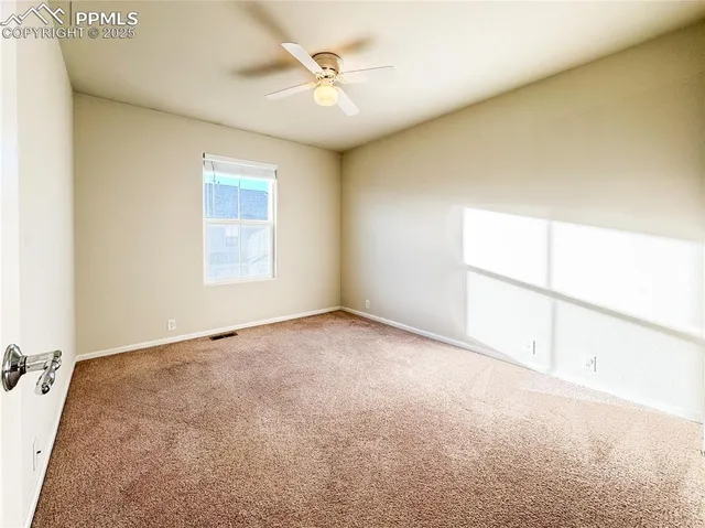 an empty room with a ceiling fan and a window