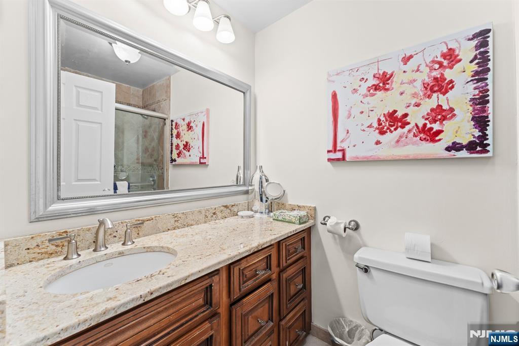 250 Gorge Road, Unit 14J Cliffside Park, NJ 07010 - Photo 12 of 45 a bathroom with a granite countertop sink mirror and toilet