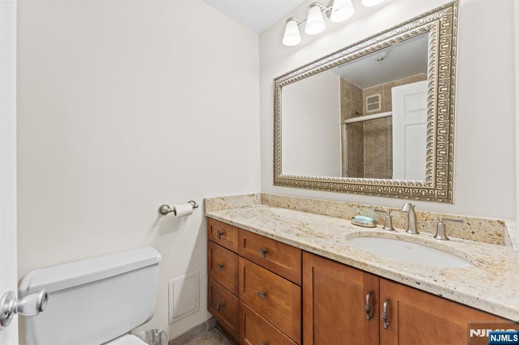 250 Gorge Road, Unit 14J Cliffside Park, NJ 07010 - Photo 17 of 45 a bathroom with a granite countertop sink a toilet and mirror