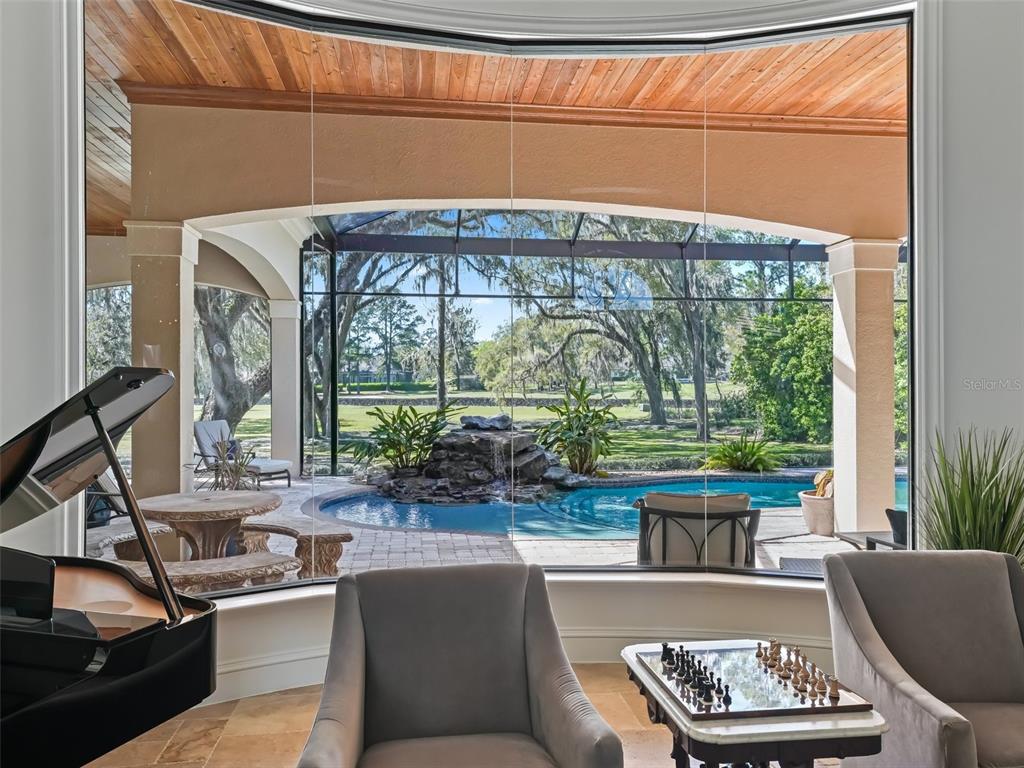 3848 Northwest 85th Terrace Ocala, FL 34482 - Photo 8 of 62 a living room with a couch a fireplace a large window and potted plants