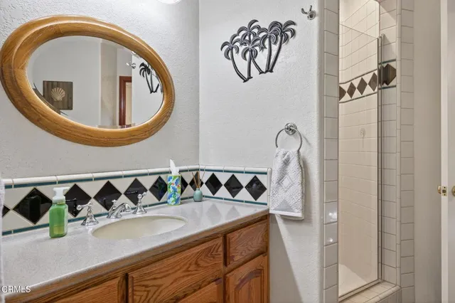 a bathroom with a granite countertop sink and a mirror