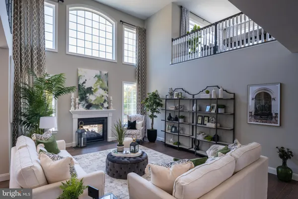 a living room with furniture a fireplace and a potted plant