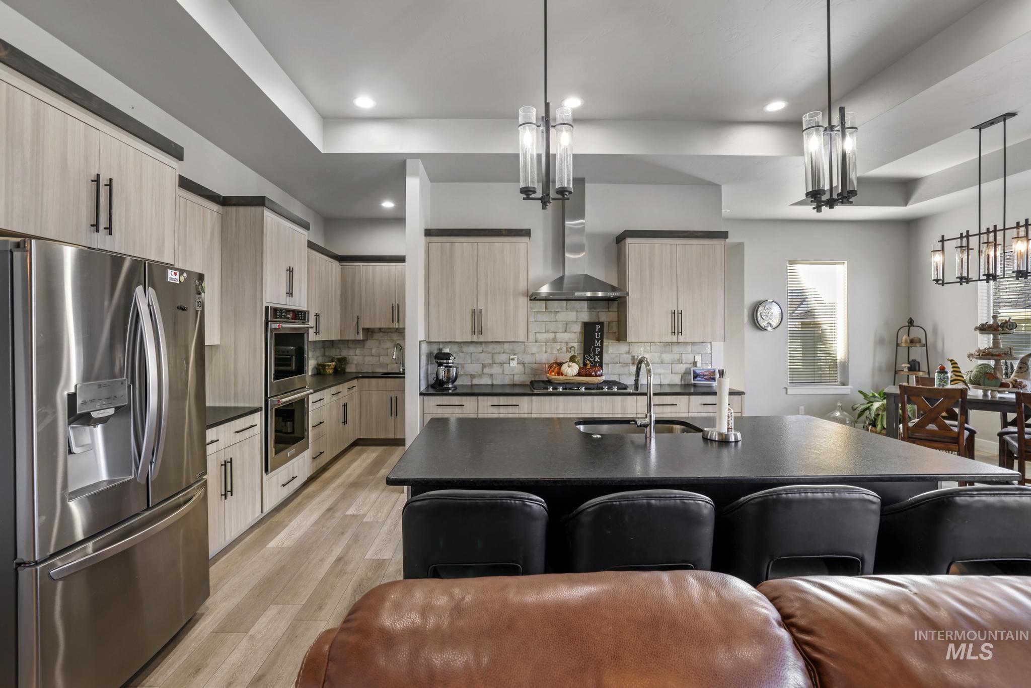 439 Meadowview Lane Twin Falls, ID 83301 - Photo 11 of 48 Kitchen featuring stainless steel appliances, light brown cabinets, a center island with sink, pendant lighting, and light wood-style flooring