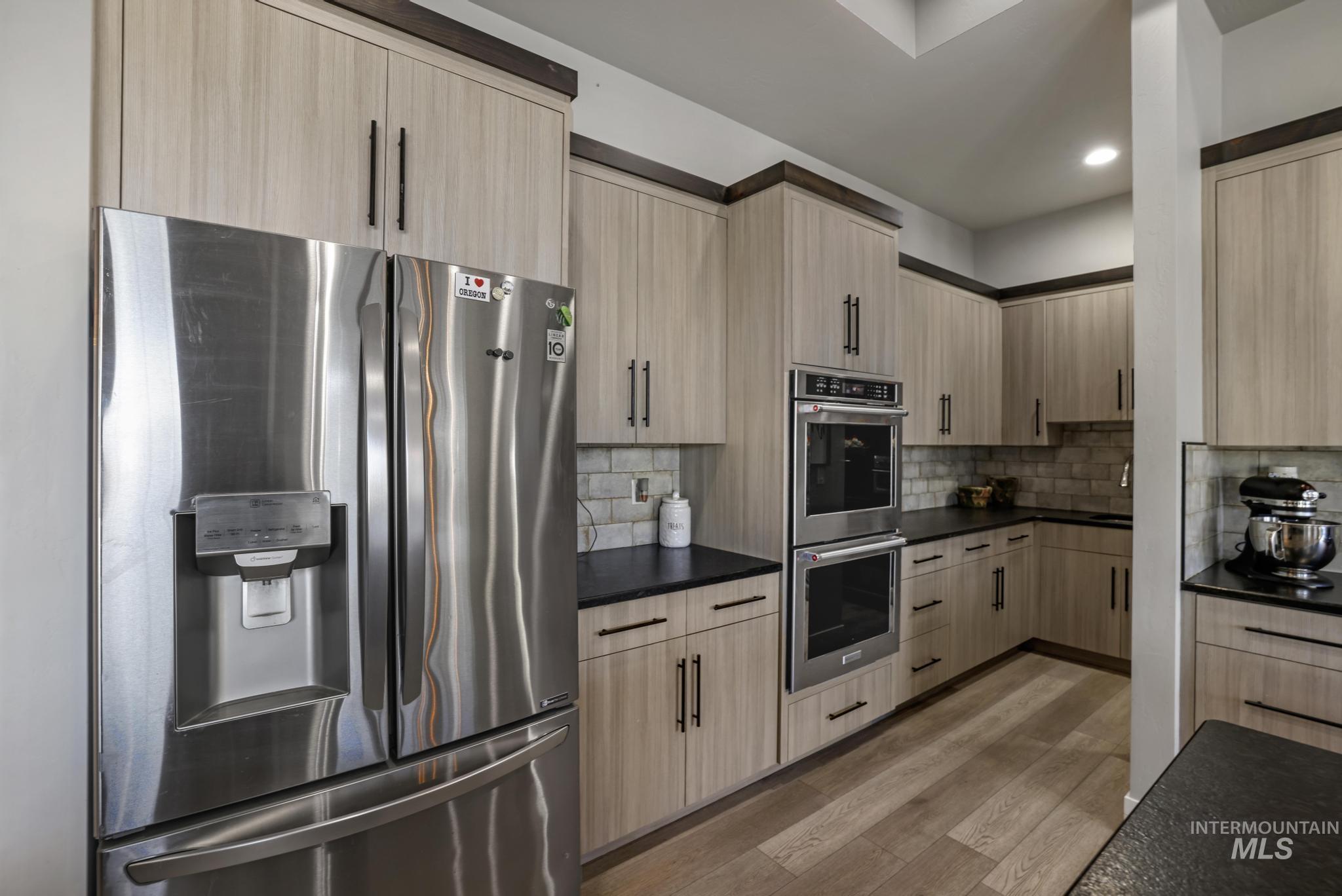 439 Meadowview Lane Twin Falls, ID 83301 - Photo 15 of 48 Kitchen featuring light brown cabinetry, stainless steel appliances, light wood finished floors, modern cabinets, and recessed lighting