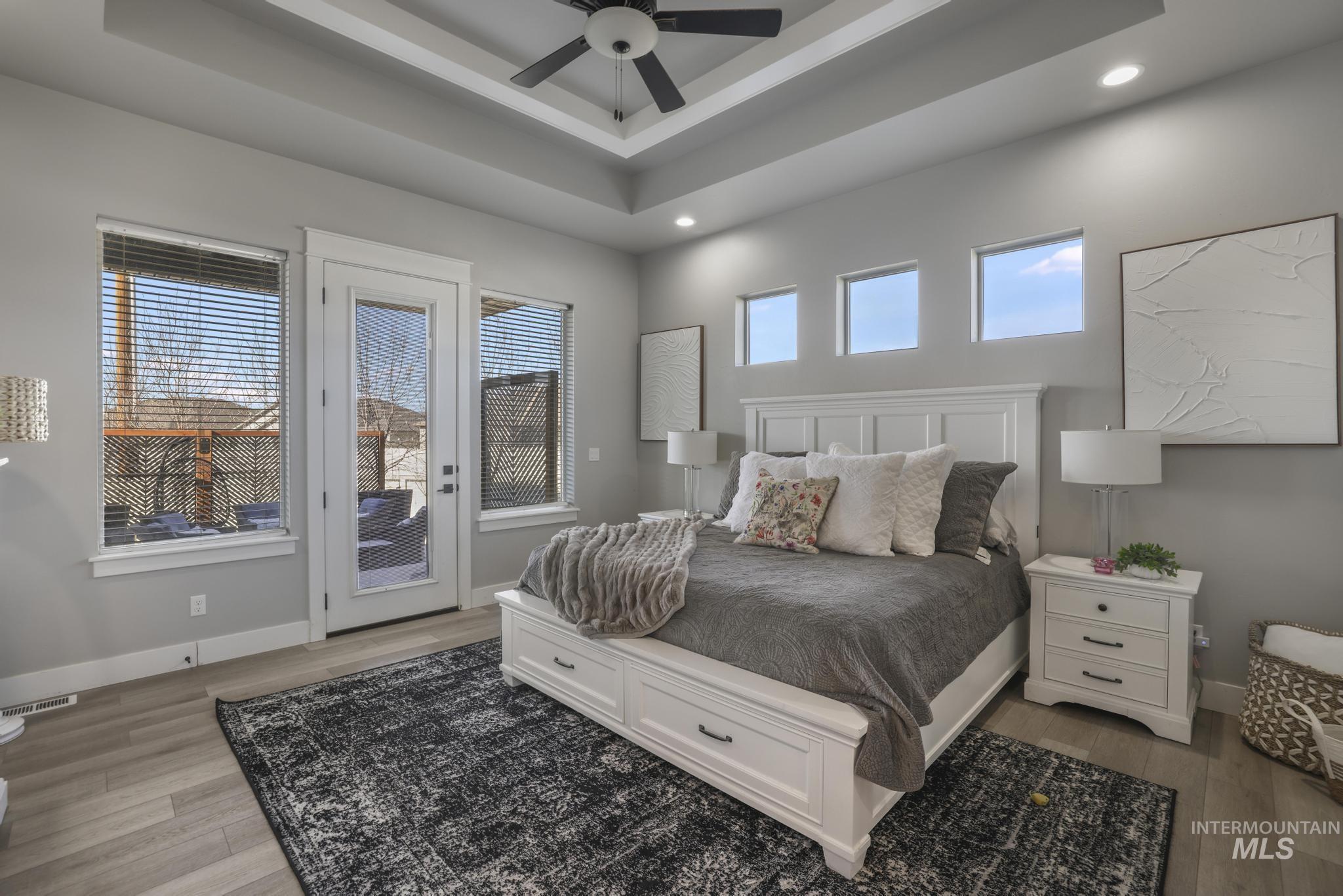 439 Meadowview Lane Twin Falls, ID 83301 - Photo 28 of 48 Bedroom featuring access to outside, light wood finished floors, a ceiling fan, a tray ceiling, and recessed lighting