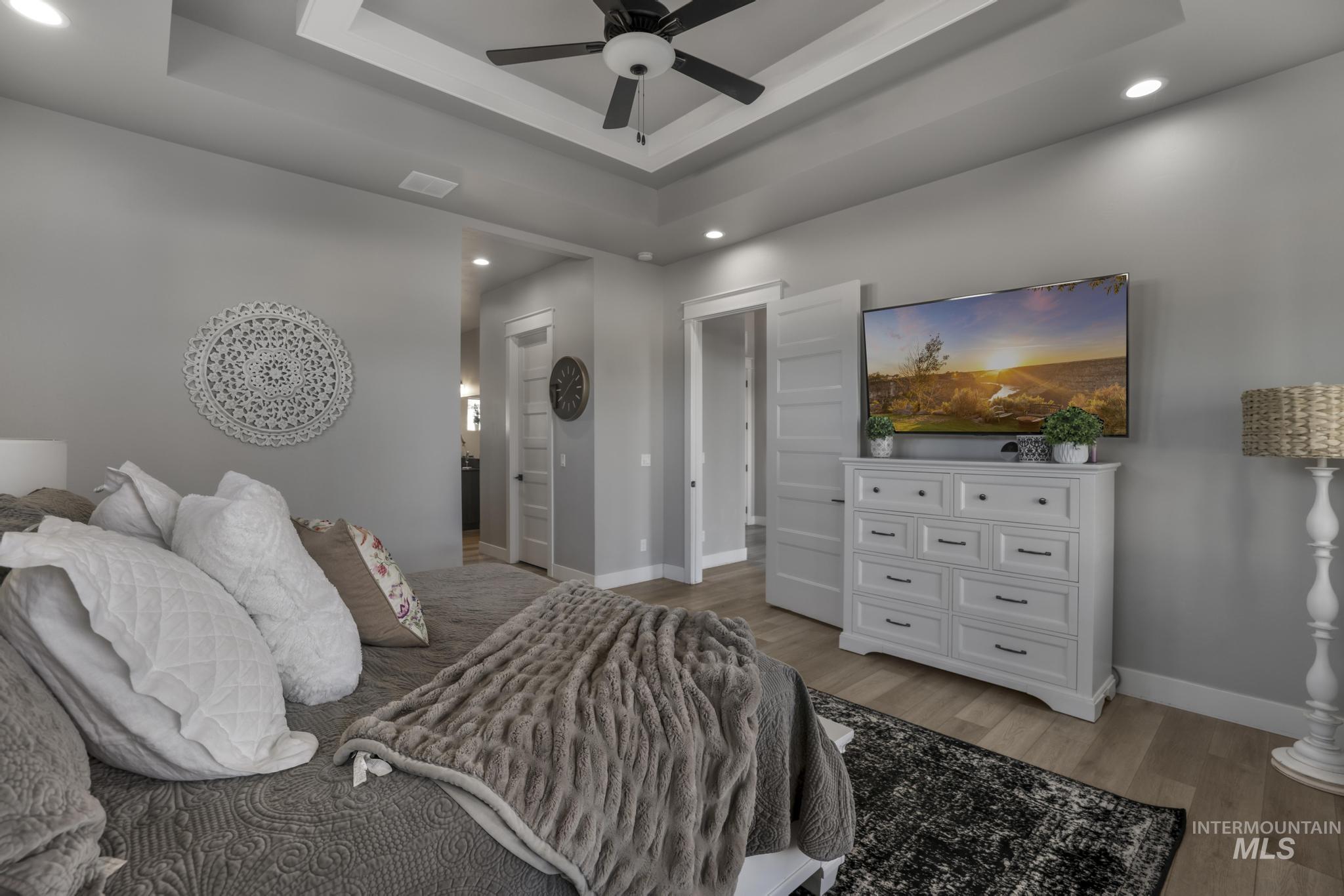 439 Meadowview Lane Twin Falls, ID 83301 - Photo 29 of 48 Bedroom with a raised ceiling, recessed lighting, light wood finished floors, a ceiling fan, and ensuite bath