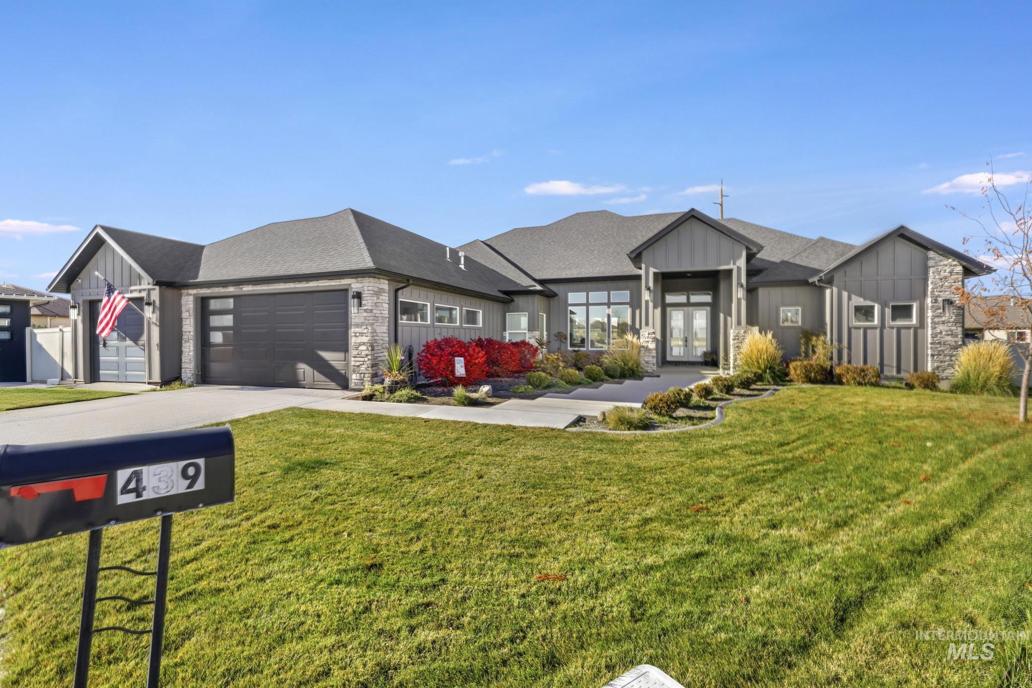 439 Meadowview Lane Twin Falls, ID 83301 - Photo 39 of 48 View of front of house with board and batten siding, a front yard, concrete driveway, french doors, and stone siding