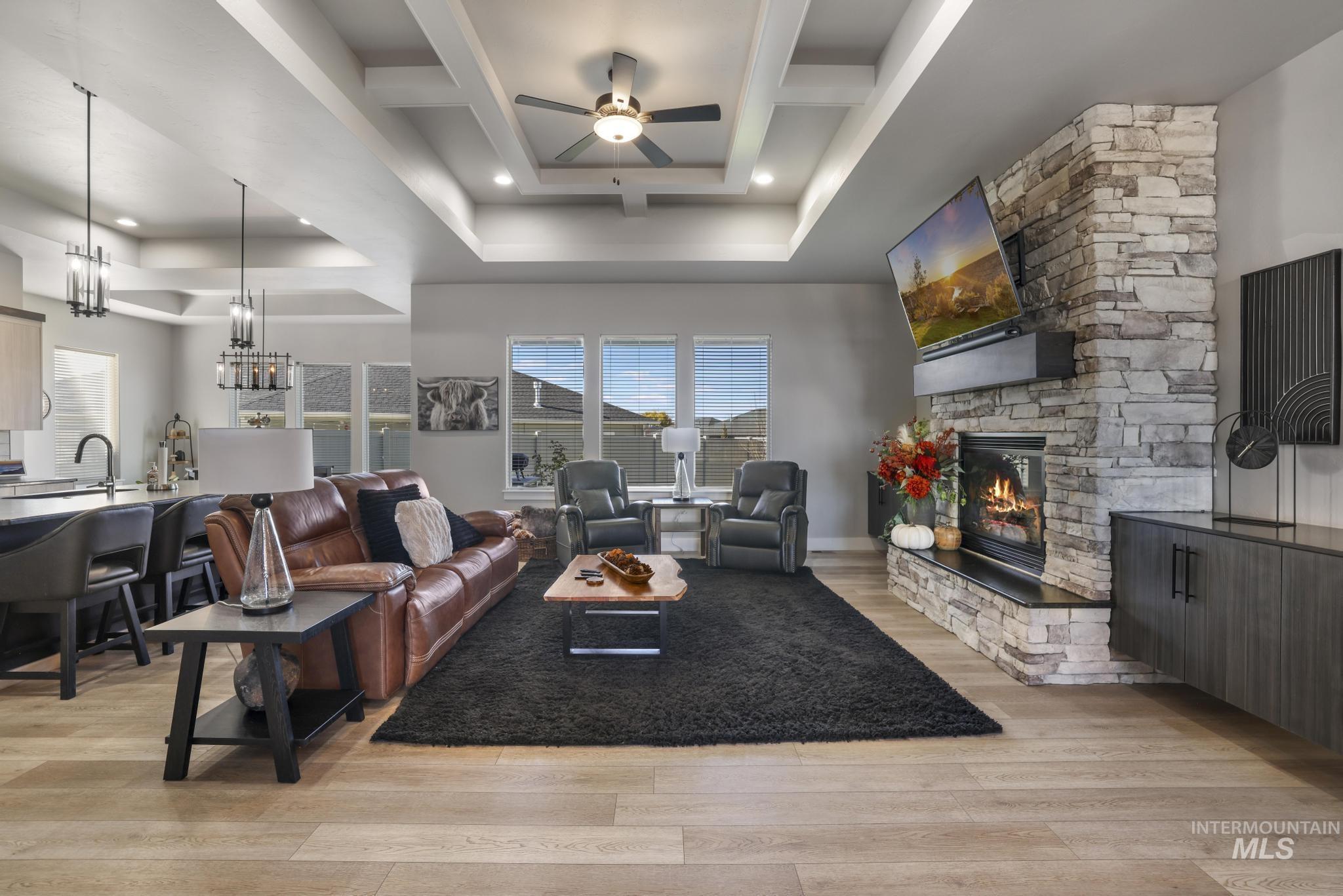 439 Meadowview Lane Twin Falls, ID 83301 - Photo 7 of 48 Living area with light wood finished floors, ceiling fan, a stone fireplace, a chandelier, and recessed lighting