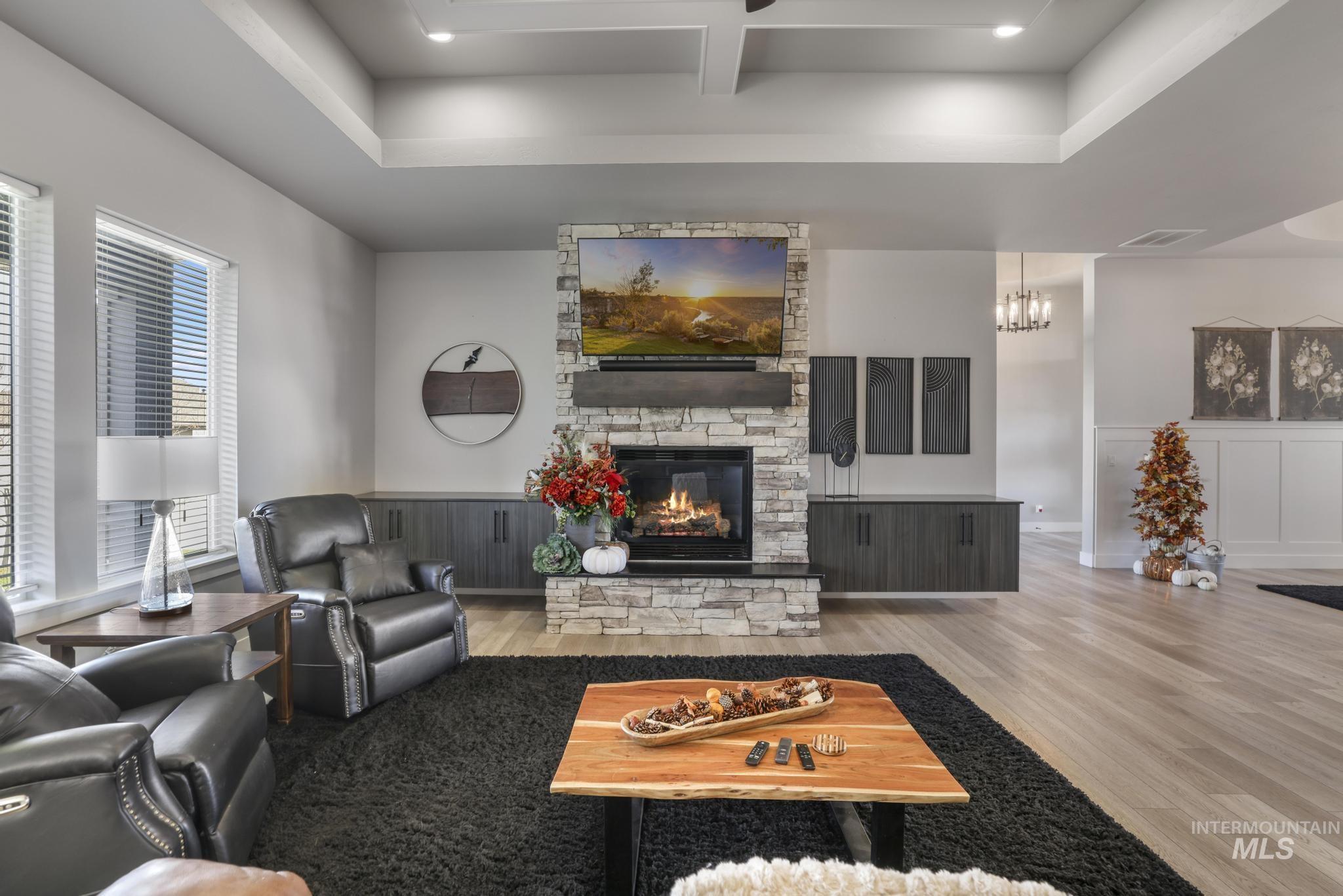 439 Meadowview Lane Twin Falls, ID 83301 - Photo 8 of 48 Living room with coffered ceiling, wood finished floors, a stone fireplace, beam ceiling, and wainscoting