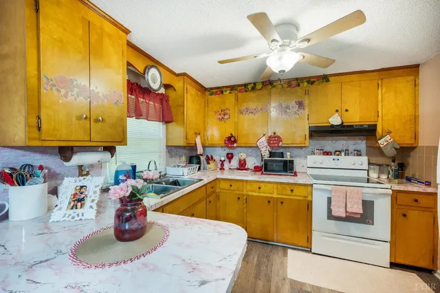 a kitchen with stainless steel appliances granite countertop a refrigerator a stove and a dining table with wooden floor