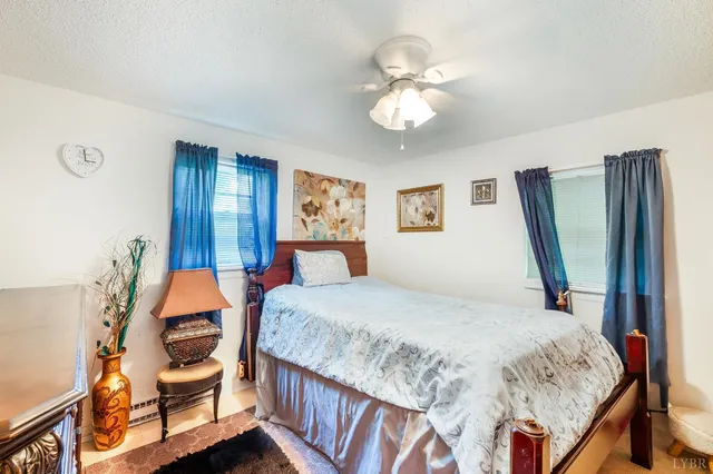 a view of a yard in front of a house with plants and large tree