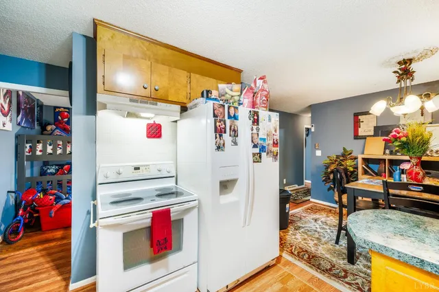 a kitchen with stainless steel appliances granite countertop a refrigerator and a stove top oven