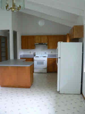 18-8023 North Kulani Road Mountain View, HI 96771 - Photo 8 of 9 a kitchen with stainless steel appliances a refrigerator a sink a stove and white cabinets