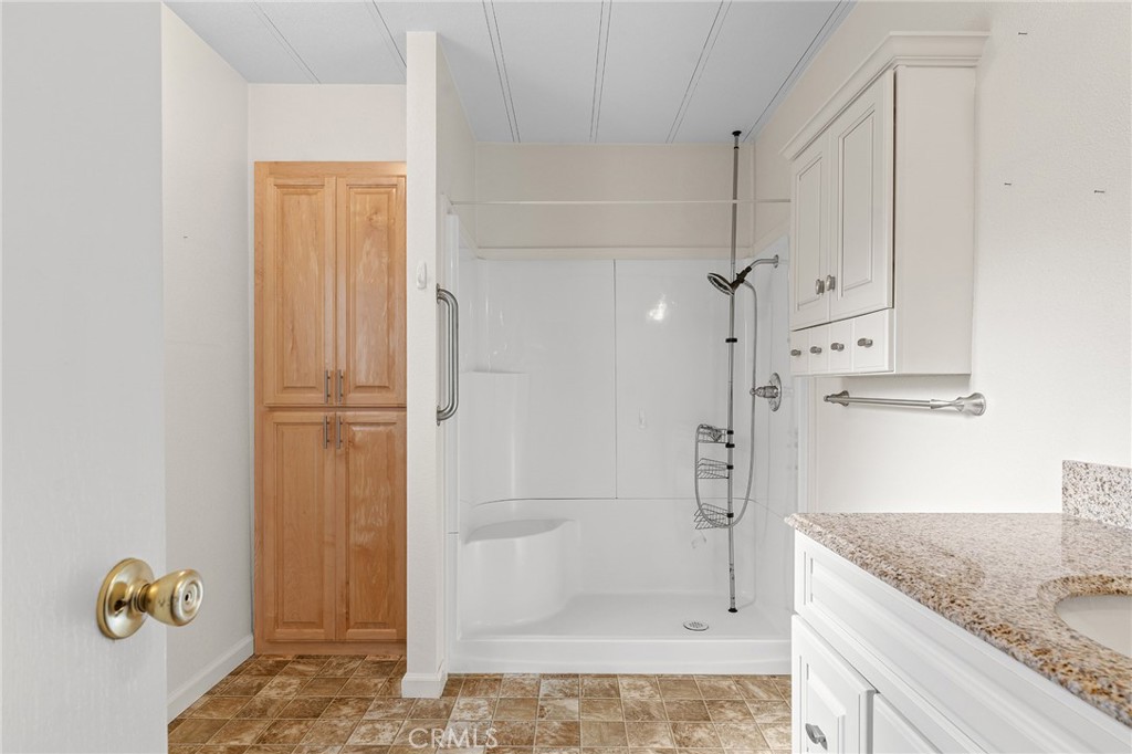 1901 Dayton, Unit 128 Chico, CA 95928 - Photo 23 of 44 a bathroom with a granite countertop sink mirror and shower