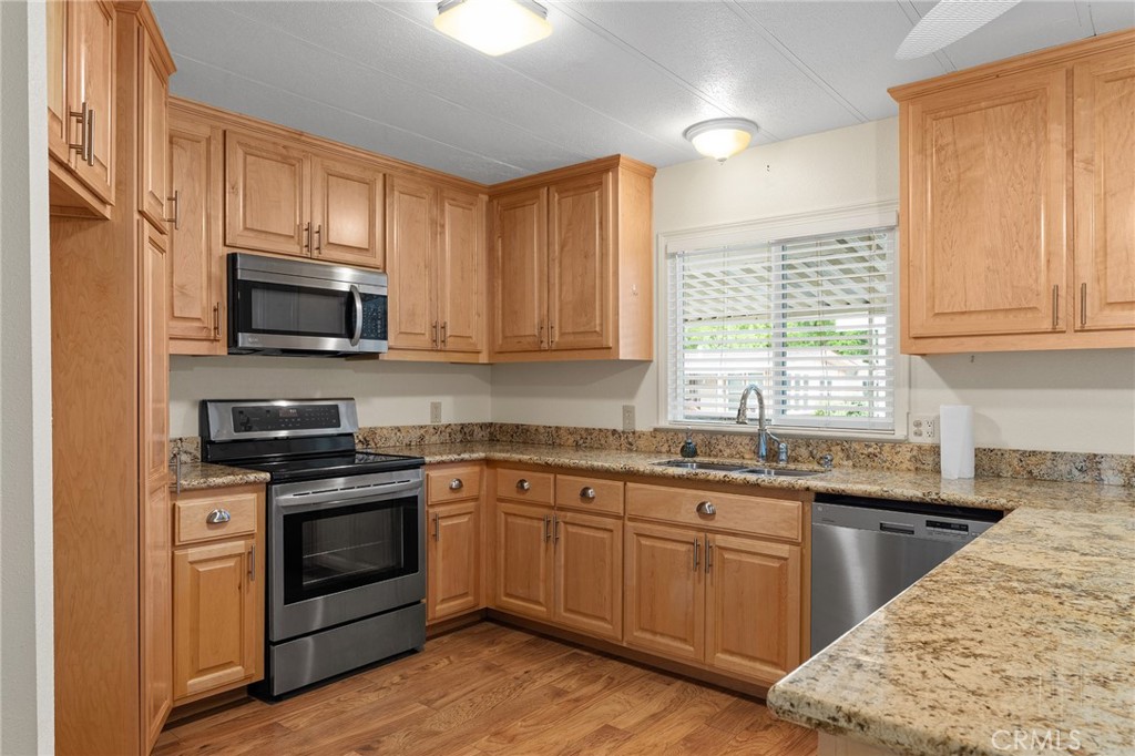 1901 Dayton, Unit 128 Chico, CA 95928 - Photo 8 of 44 a kitchen with stainless steel appliances granite countertop a sink stove microwave and refrigerator