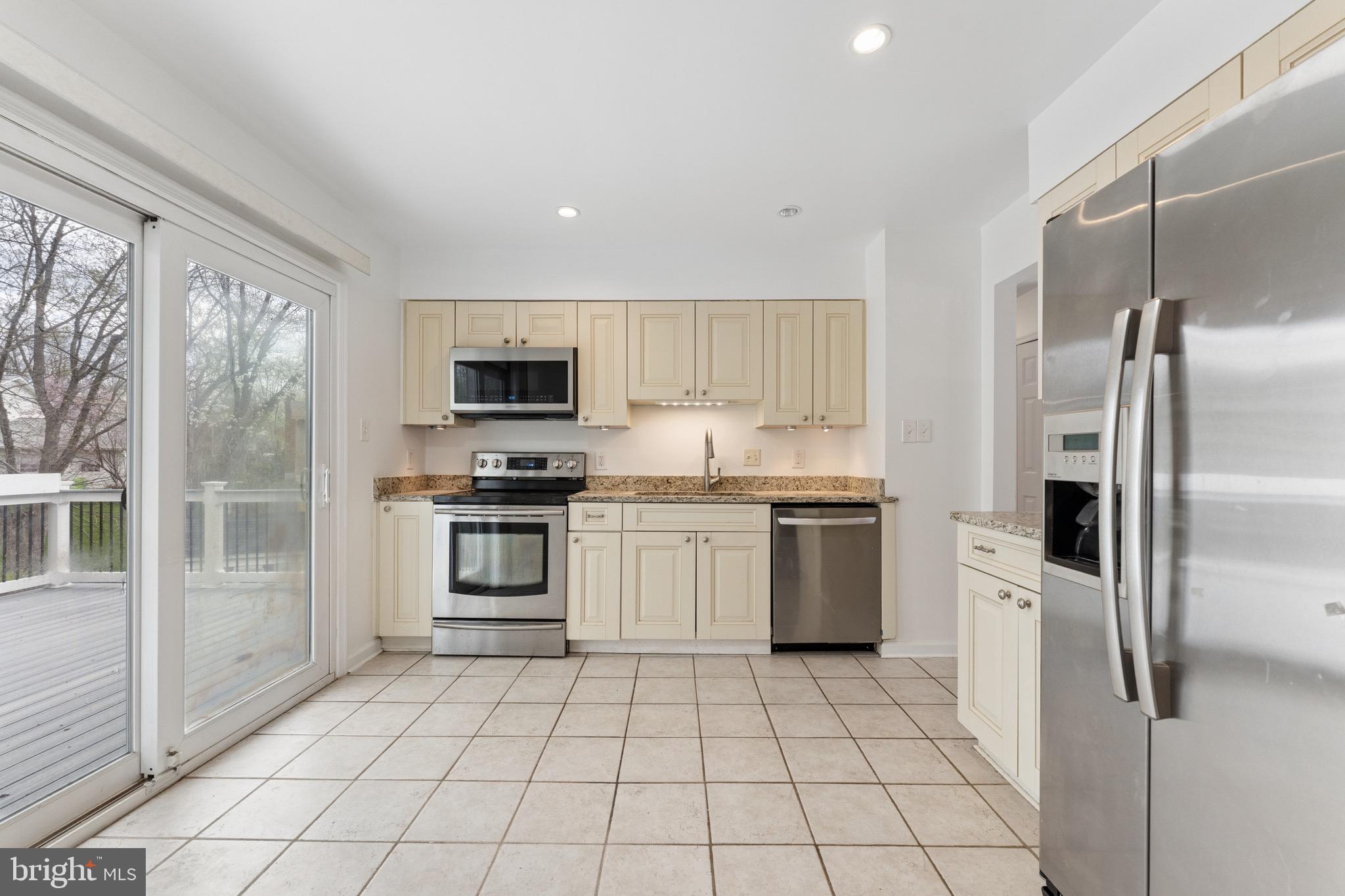 8910 Spur Road Springfield, VA 22153 - Photo 11 of 45 a kitchen with a stove a microwave and a refrigerator