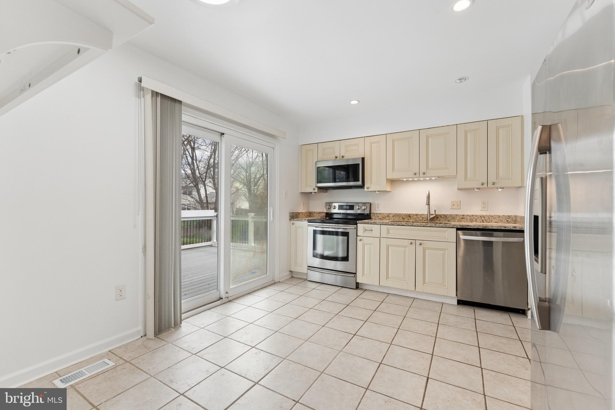 8910 Spur Road Springfield, VA 22153 - Photo 12 of 45 a kitchen with a refrigerator sink and cabinets